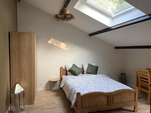 a bedroom with a large bed with a skylight at La bergerie in La Bruyère