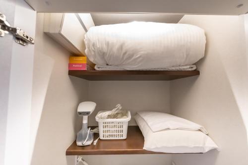 a room with two shelves with a bed and a pillow at Hotel Liberte Kyoto Gojo in Kyoto