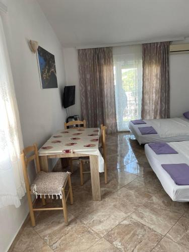 a bedroom with a table and a bed and a table and chair at Apartments Neda in Sutomore