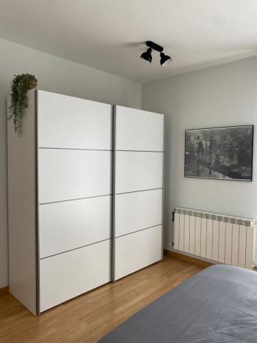 Biała sypialnia z dużą białą szafą w obiekcie Habitación en casa de Mikel w mieście Olite