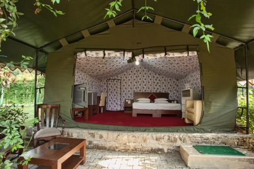 a bedroom in a tent with a bed in it at Flag House Resort in Jūnga