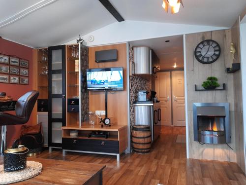 un salon avec une télévision et une cheminée dans l'établissement LE PETIT BONHEUR, à Pont-Aven