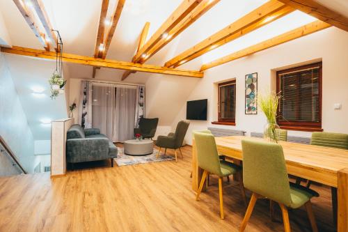 a living room with a wooden table and chairs at Penzion Tilia in Český Krumlov