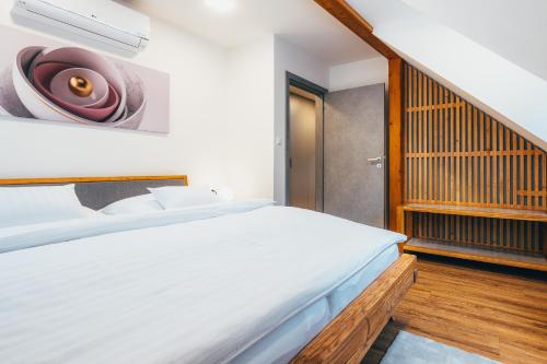 a bedroom with a white bed and a staircase at Penzion Tilia in Český Krumlov