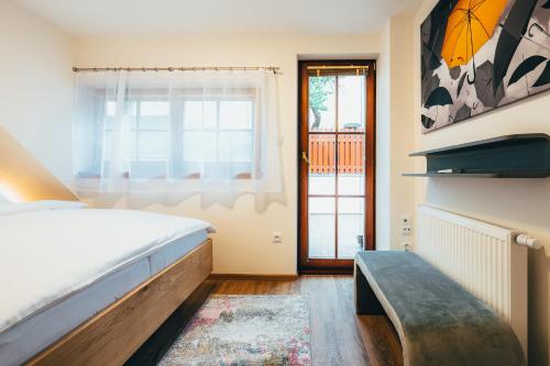 a bedroom with a bed and a window and a bench at Penzion Tilia in Český Krumlov