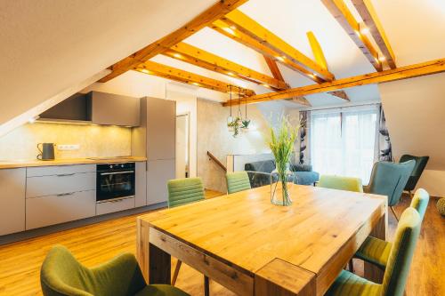 a kitchen and dining room with a wooden table and chairs at Penzion Tilia in Český Krumlov