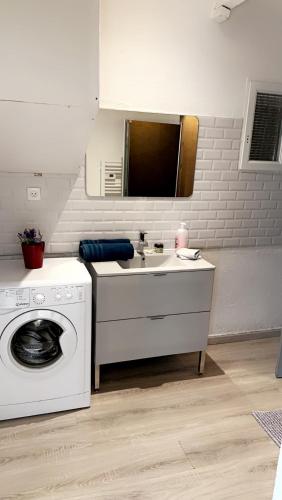 une salle de bain avec une machine à laver et un lavabo dans l'établissement La lavande, à Arles