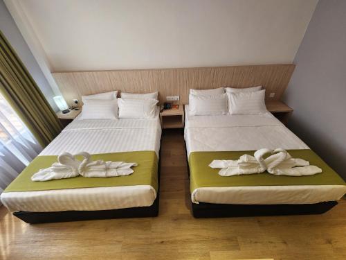 two beds in a hotel room with towels on them at Hotel Marudu Inn in Pingan Pingan
