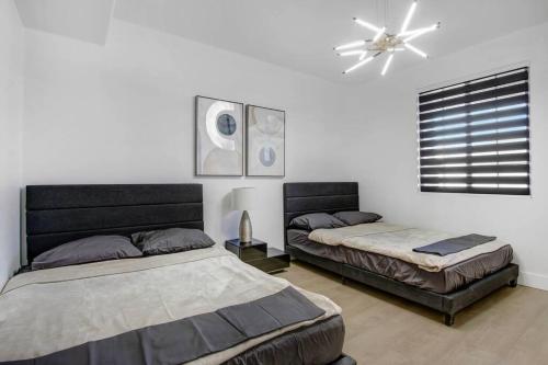 um quarto com 2 camas e uma ventoinha de tecto em Modern Luxury Home w/ Private Pool & Spa 2.0 em Indio