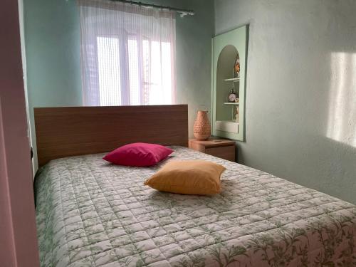 a bedroom with a bed with two pillows on it at The Great Balcony in Ioulida