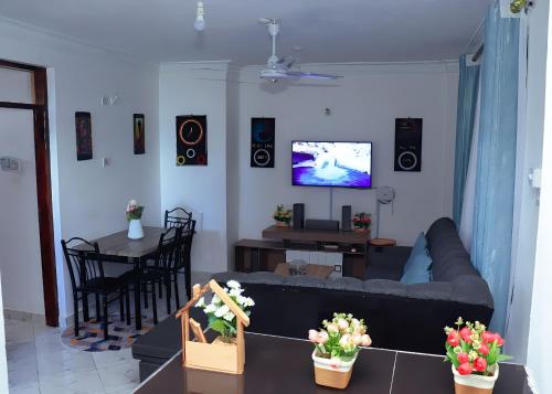 - un salon avec un canapé, une table et une télévision dans l'établissement Bamburi 2BR Apartment, à Mombasa