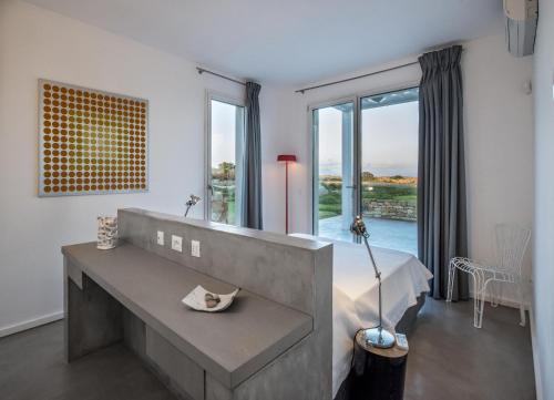 Zimmer mit einem Tisch und einem großen Fenster in der Unterkunft Villa Partenope in Favignana