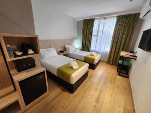 a hotel room with two beds and a television at Hotel Marudu Inn in Pingan Pingan
