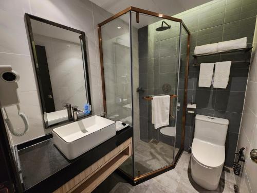 a bathroom with a sink and a shower and a toilet at Hotel Marudu Inn in Pingan Pingan
