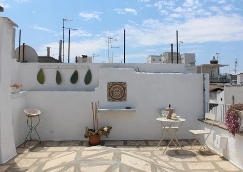 balcón con paredes blancas, mesa y sillas en L'Angolo di Ostuni - Home&Terracex4, en Ostuni