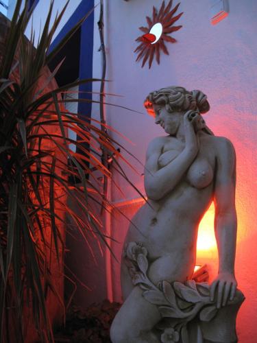 a statue of a man sitting next to a building at Pensión La Herradura in La Herradura