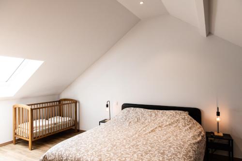 een slaapkamer met een bed en een wieg bij Le panorama in Dinant