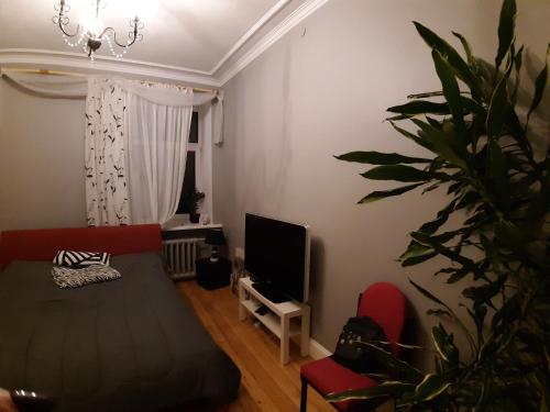 a living room with a couch and a tv at Eksporta 10, LUX in Rīga