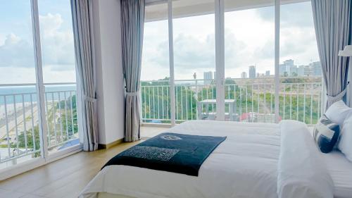 a bedroom with a bed and a large window at La Vogue Boutique Hotel & Casino in Sihanoukville