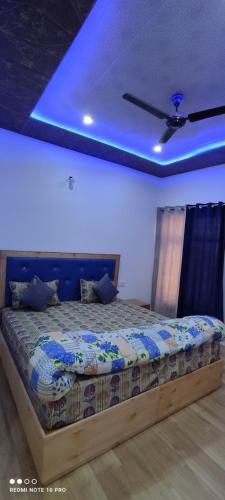 a bedroom with a bed with a blue ceiling at Noor Guest House in Leh