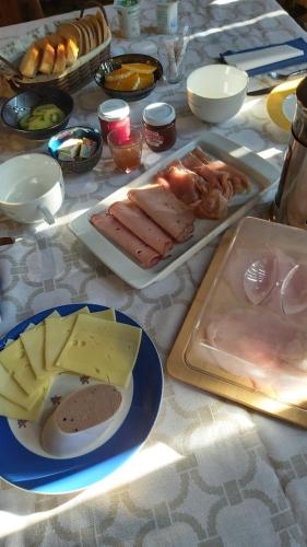 a table topped with plates of food and cheese at Herbes et collines in Winkel