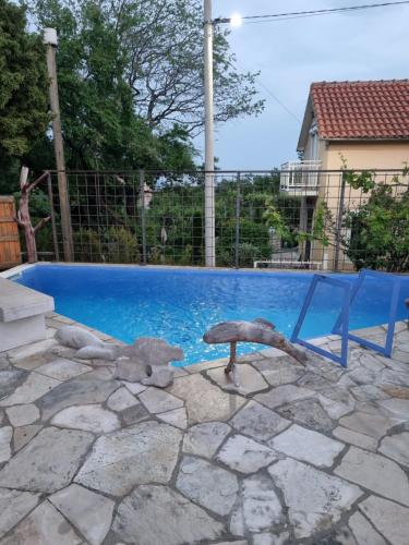 una piscina azul con una silla junto a ella en Guest house Duletic, en Budva