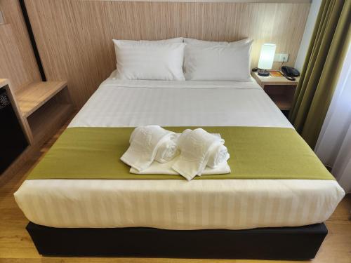 a hotel room with a bed with towels on it at Hotel Marudu Inn in Pingan Pingan