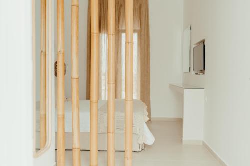 um quarto com postes de bambu à volta de uma cama em Avanti em Chora, Ios