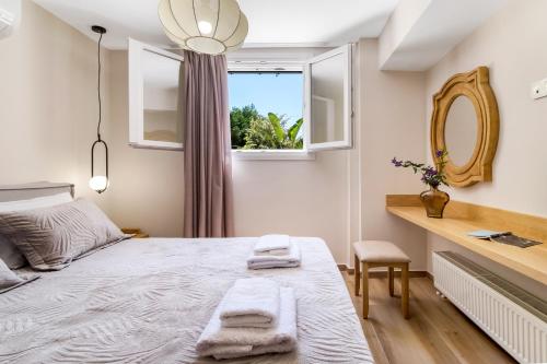 um quarto com uma cama, uma janela e um espelho em Polys Villa Lefkada 1 em Lefkada