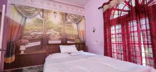 um quarto com uma cama e uma grande janela em JJ's White House em Thrissur