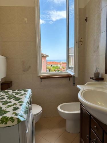 リーヴァ・リーグレにあるAppartamento vicino al mare con parcheggioの洗面台、トイレ、窓のあるバスルーム