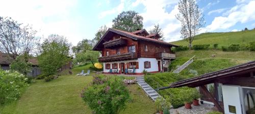 ein großes Holzhaus auf einem grasbewachsenen Hügel in der Unterkunft Opas Bergchalet in Halblech