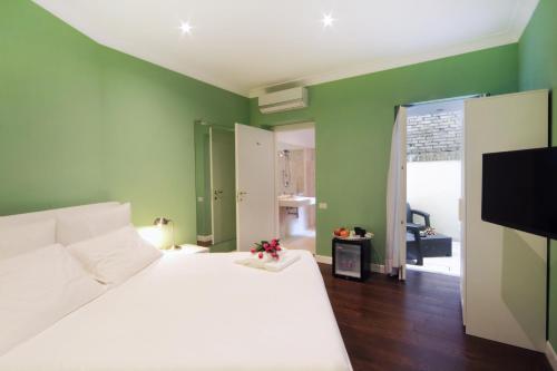 sypialnia z białym łóżkiem i zielonymi ścianami w obiekcie The One Prati Rooms w Rzymie