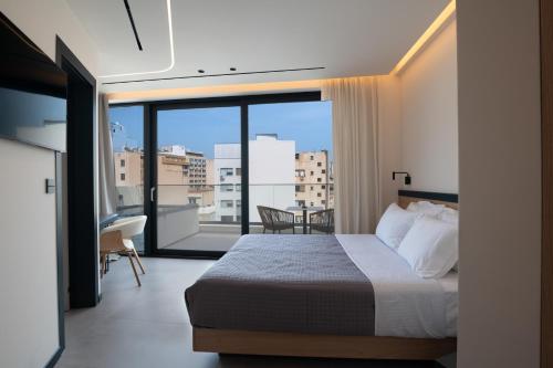a bedroom with a bed and a balcony with a view at Nema Hotel Athens in Athens