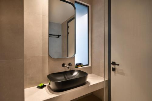 a bathroom with a black sink and a mirror at Nema Hotel Athens in Athens