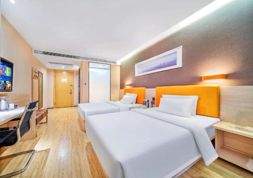 a bedroom with a large white bed and a desk at 7 Days Premium - Kunming South High Speed Railway Station University Town Metro Station in Kunming