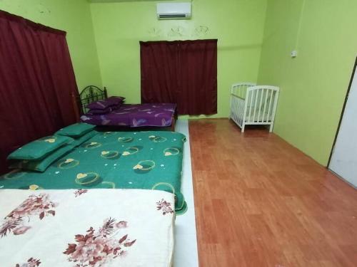 um quarto com 2 camas e piso em madeira em Hajjah Homestay Tg Agas Muar em Muar