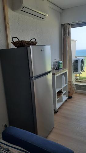 una nevera blanca en una habitación con ventana en Happy 7, en Canet-en-Roussillon