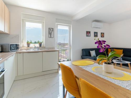 a kitchen and living room with a wooden table and yellow chairs at Apartment Harmony in Umag