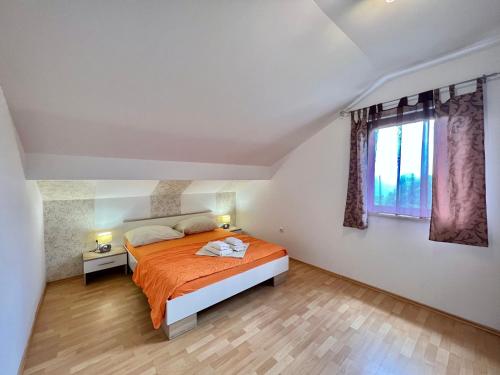a bedroom with a bed and a window at Apartman Milly in Grižane