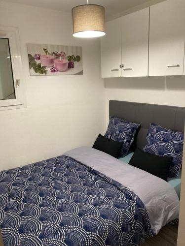 una camera da letto con un letto con lenzuola e cuscini blu di Appartement vacances cap d’agde a Cap d'Agde