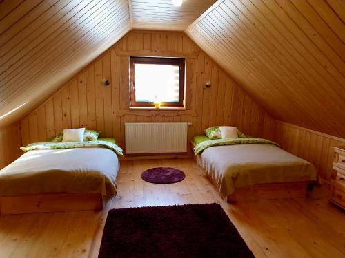 twee bedden in een kamer met een zolder bij Domek u Bartusia in Wisła