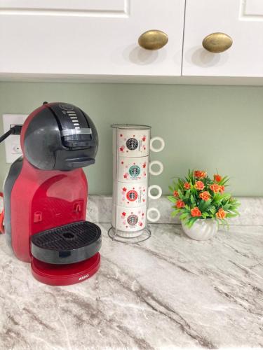 a red coffee maker on a counter in a kitchen at Casa lazer completo 200m da praia in Praia Grande