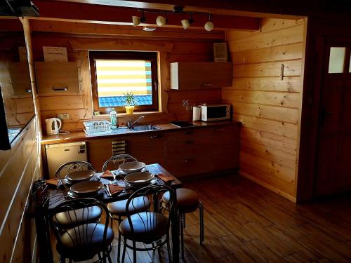 a kitchen with a table and chairs in a cabin at Domek u Bartusia in Wisła