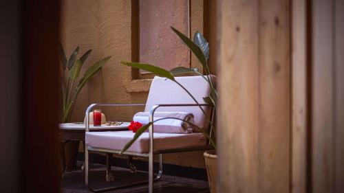 a white chair sitting next to a table with a plant at YAAN Udaipur in Udaipur