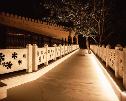 a fence with lights on the side of a building at YAAN Udaipur in Udaipur