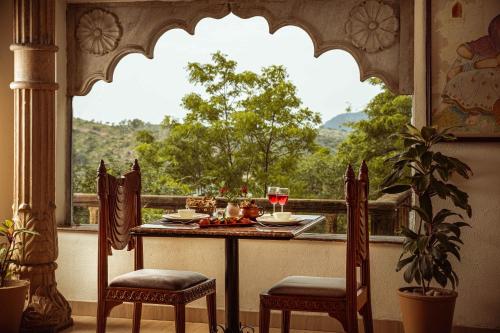 a table and chairs in front of a window with a view at YAAN Udaipur in Udaipur
