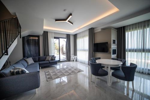 ein Wohnzimmer mit einem Sofa und einem Tisch in der Unterkunft Artan Suites Tatil Evleri in Güzelçamlı
