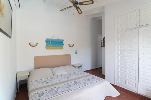 1 dormitorio con cama y puerta blanca en Finca El León en Benissa
