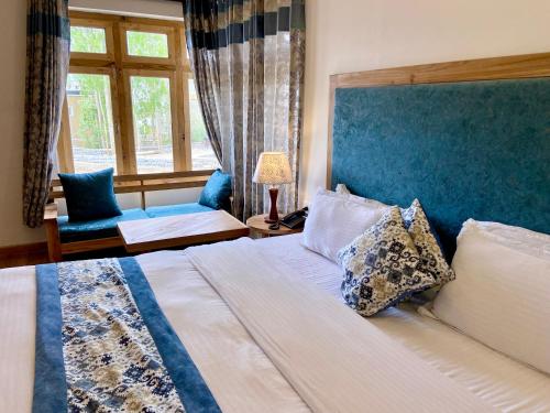 a bedroom with a large bed with a blue headboard at hotel palam hills in Leh